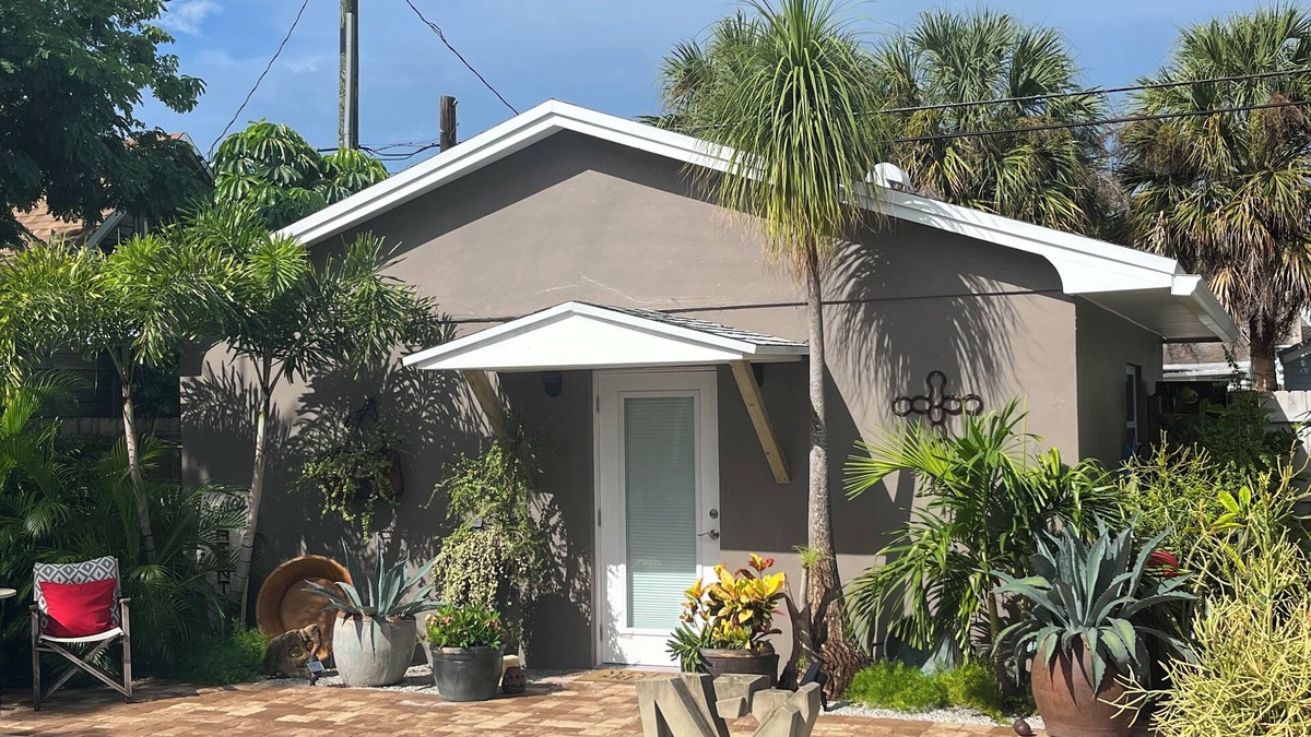 Parrot Cove Cottage | Chill on the patio overlooking the pool & lush gardens with privacy!