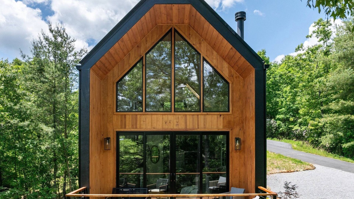 Young Harris Cabin | Romance meets design at Viking Hut, a Scandinavian 1BR retreat in the North Georgia mountains. Floor-to-ceiling windows frame fiery fall leaves, a skylight invites stargazing from your king bed, and a fenced yard makes it perfect for pups.