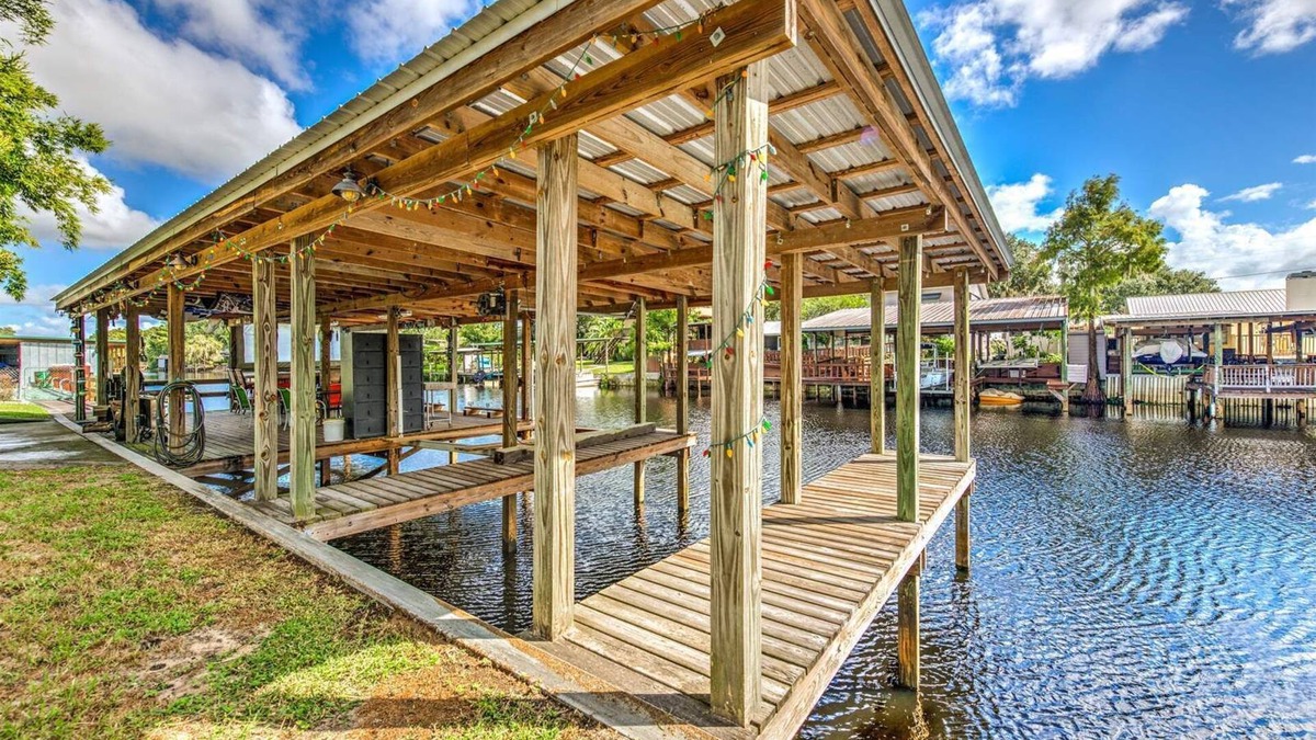 Fedhaven House | Tropical Lake House with waterfront tiki bar and wrap around porch