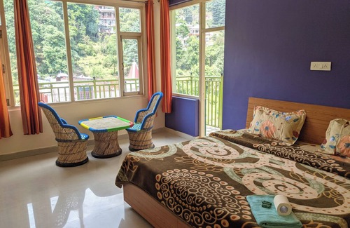 Dharamshala Bed & Breakfast | Golden View BnB Mcleodganj nRoom with private balcony facing mountain view.