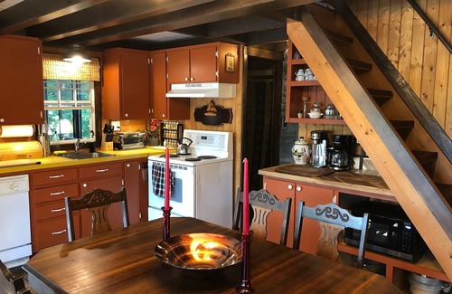 Cap-Pele Ski Chalet | Luxurious rustic wooden chalet on edge of tranquil pond in nature next to beach.