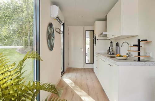 Maasbree House | Modern 4-person lodge extending 12 metres over the water, with walk-in shower, designer kitchen and stunning lakeview terrace.