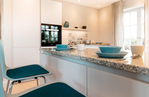 Großmorsum House | New building under thatch with an unobstructed view of the water.