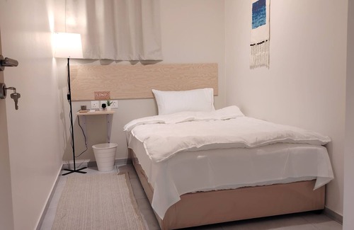 Buraydah Cabin | Private room 8m for men. Bed, AC, side table, Wi-Fi. Shared baths, lounges.