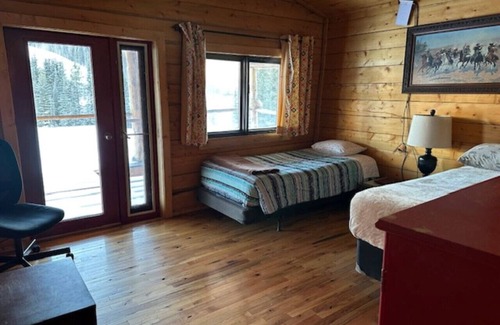 Buckinghorse River Cabin | Room 6 at the Main Lodge with a queen bed and single bed.