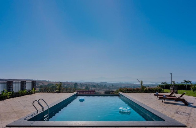Breezy Whispers by StayVista - Private infinity pool, Stunning mountain views, Spacious swimming pool, Deck & Lawn