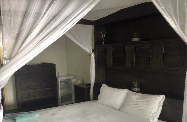 Clean tidy hotel room with a shared kitchen and shower area