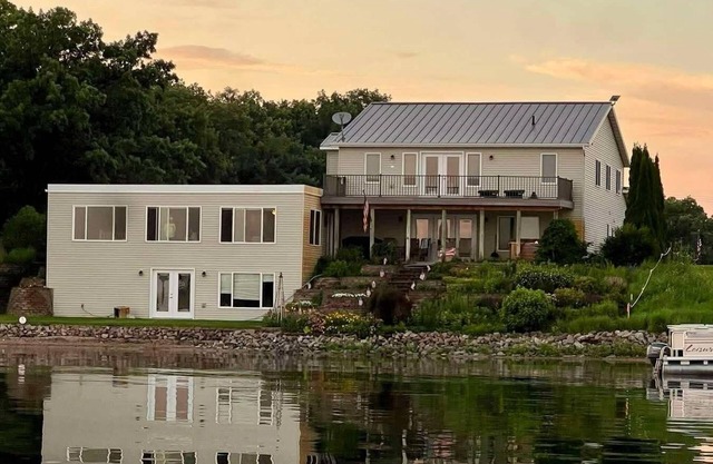 Gather at this spacious 5-bedroom lake home with 277' sandy beach, private dock