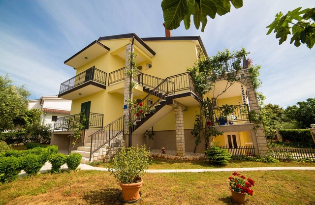 House with garden, opposite is a green park with toys.
