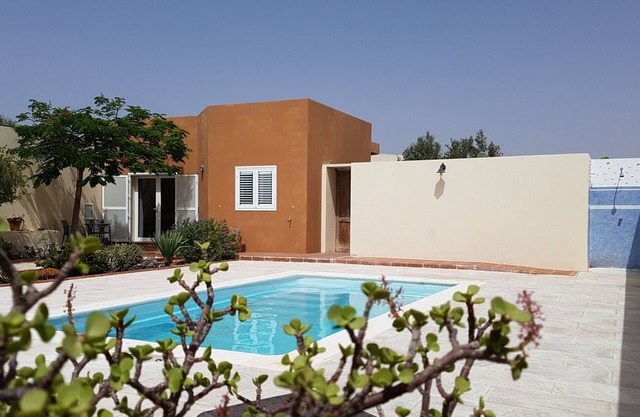 House with pool between gardens and olive farm.