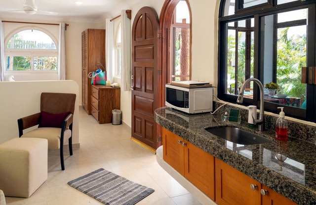 Large studio with king bed, full kitchen, sofa bed. Half wall separating.