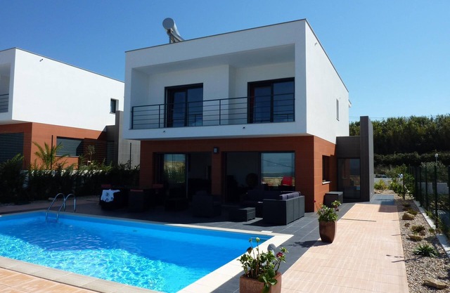 Luxury modern villa with private swimming pool and unique view of ocean and mountain landscape