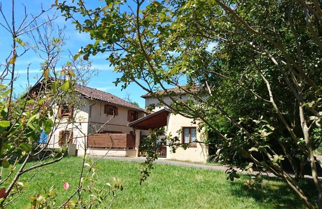 Maison colorée et chaleureuse avec terrasse et jardin.