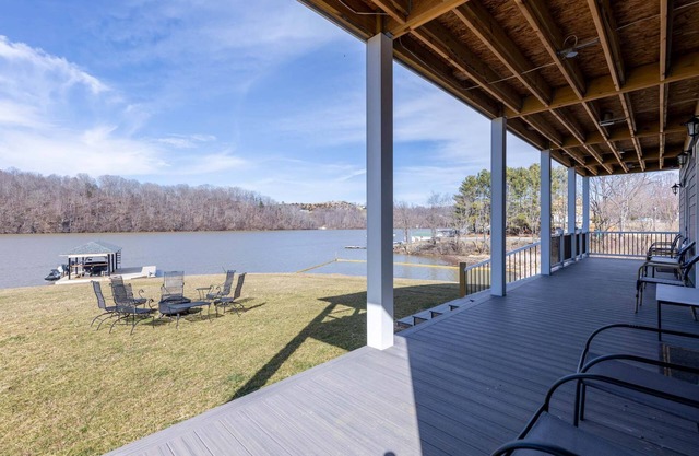 Modern lakefront home with wraparound decks, firepit, and stunning water views on both levels.