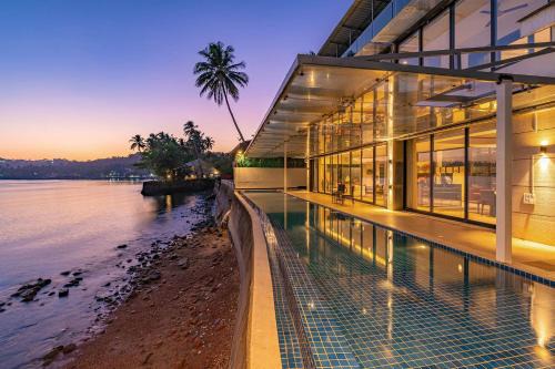 Oceanic Sunsets with River View, Comp Breakfast & Infinity Pool at StayVista