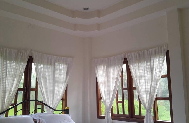 Traditional Thai wooden house on stilts set in a coconut orchard near the beach