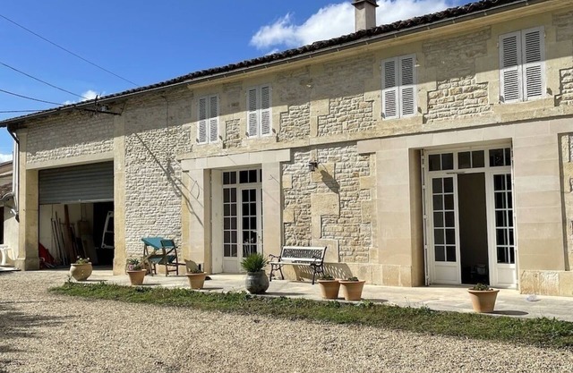 Typical Charente farmhouse with enclosed garden planted with trees.