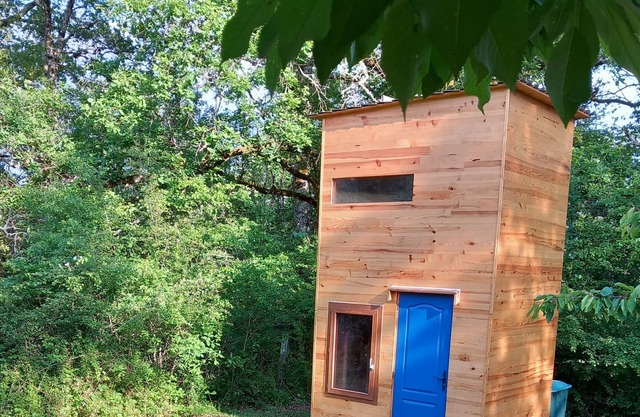 Wooden hut accessible by a path at the edge of the woods